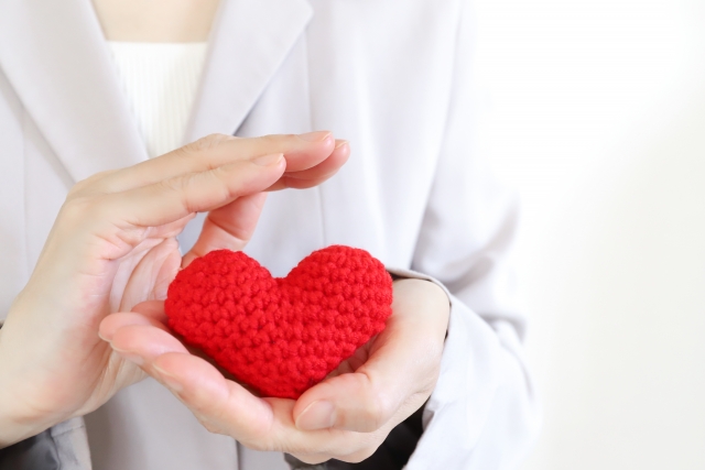 赤いハートを持った手元 サポートイメージ