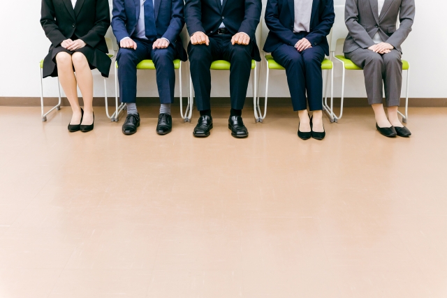 オフィスで椅子に座るスーツ姿の会社員